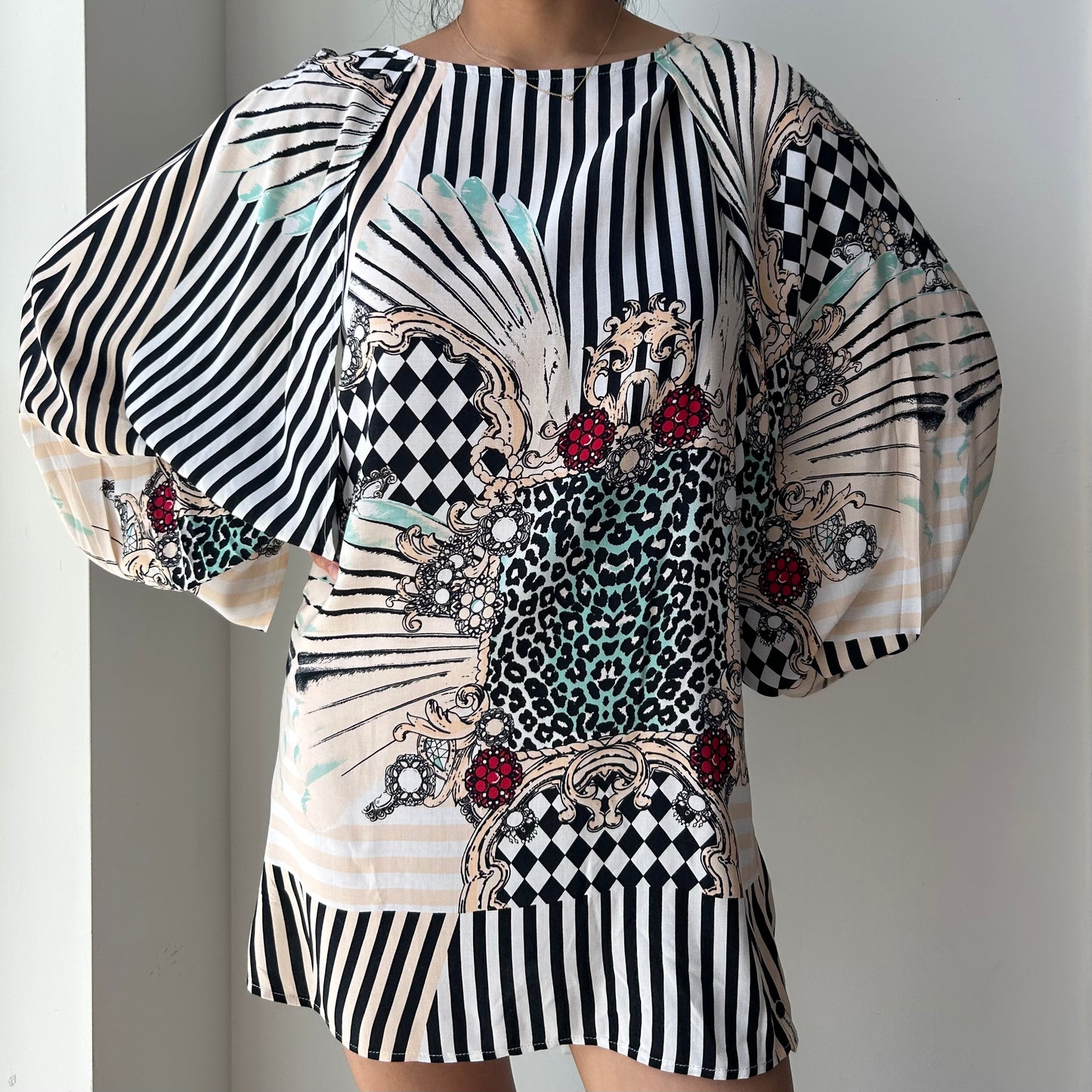 Black and white patterned dress with embellishments on a plain background