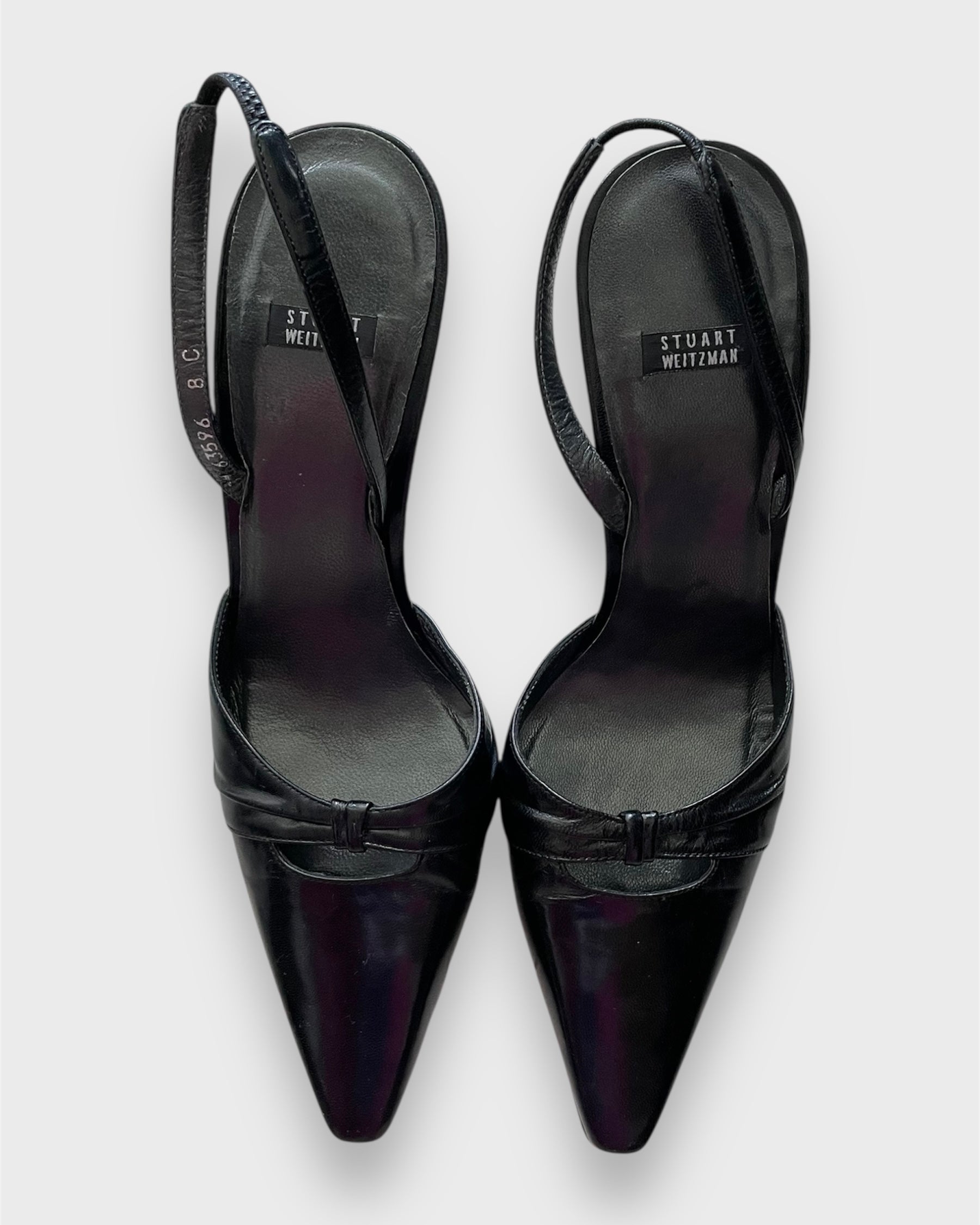Black high-heeled shoes with 'Stuart Weitzman' branding on a white background