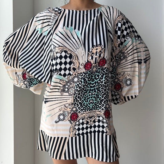Black and white patterned dress with embellishments on a plain background