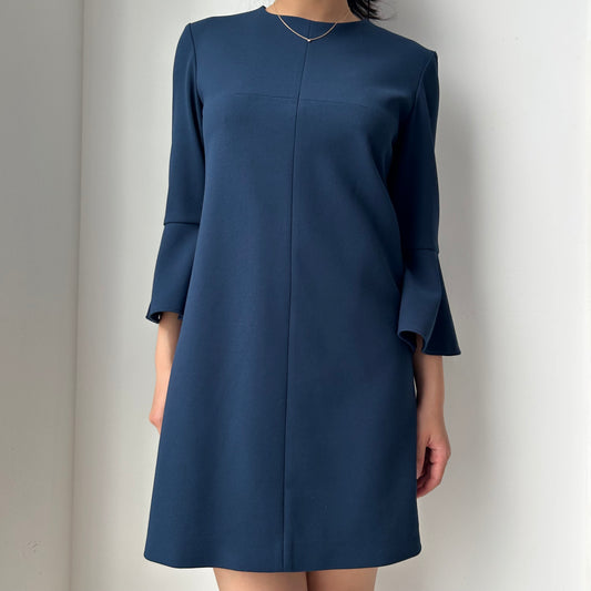 Navy blue dress worn by a person on a plain background