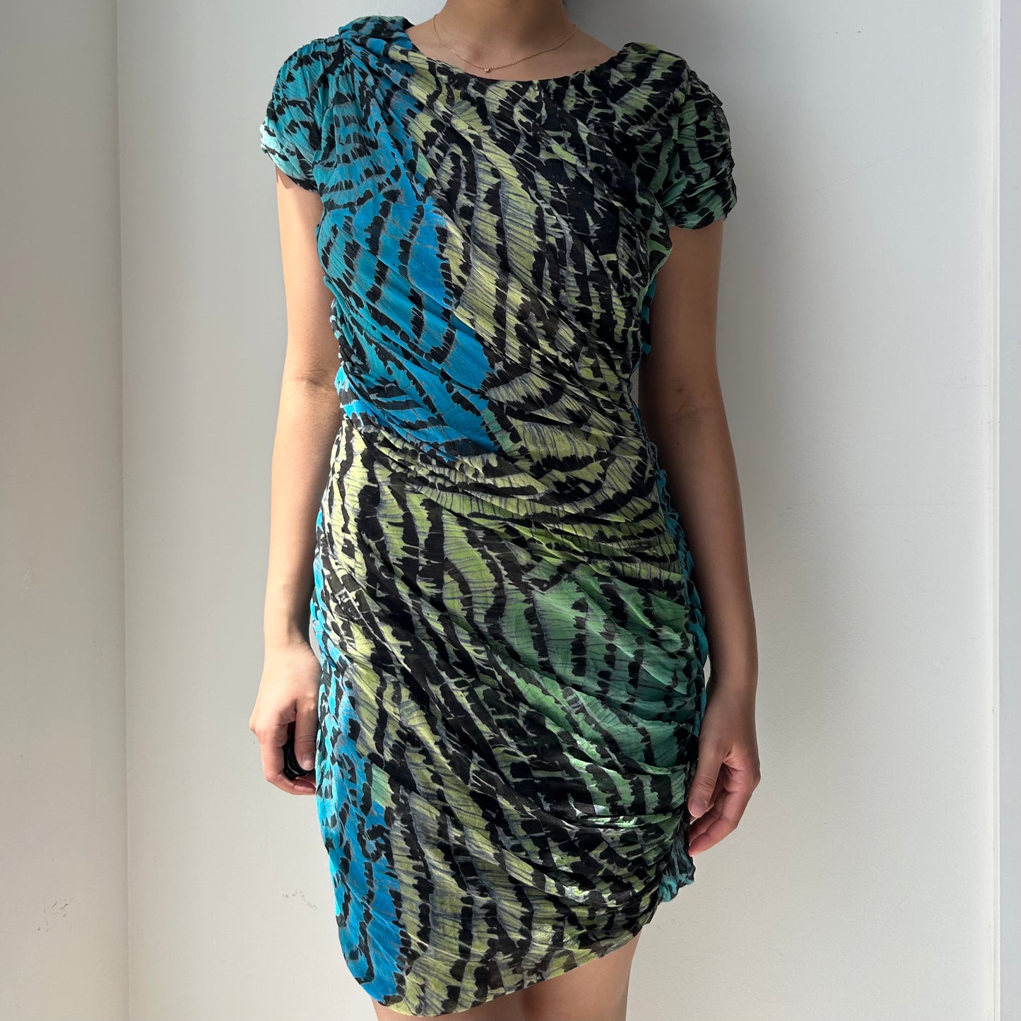 Multicolored patterned dress worn by a person against a plain background