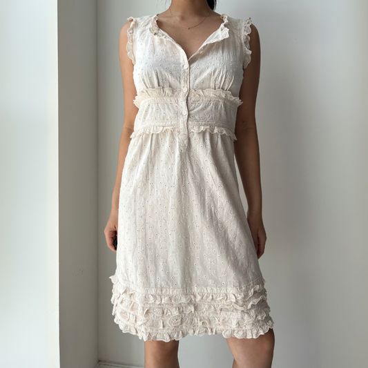 White lace dress worn by a person against a plain background